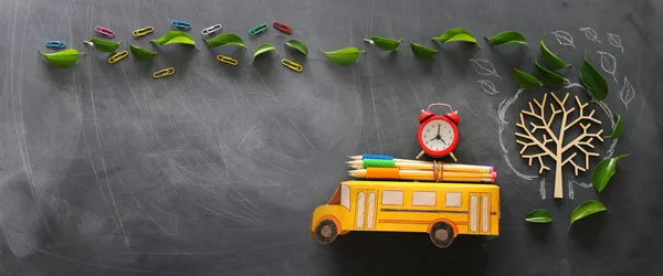 Onderwijs en terug naar school concept. Top View foto van schoolbus en potloden op het dak naast boom met herfst bladeren over klaslokaal Blackboard achtergrond. bovenaanzicht, vlakke lay — Stockfoto