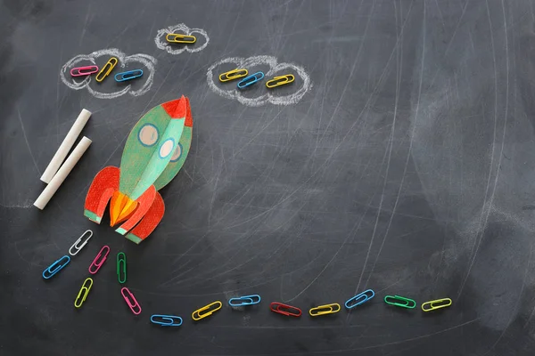 Onderwijs. Terug naar school concept. raket uit papier gesneden en over schoolbord geschilderd. bovenaanzicht, vlak lay — Stockfoto