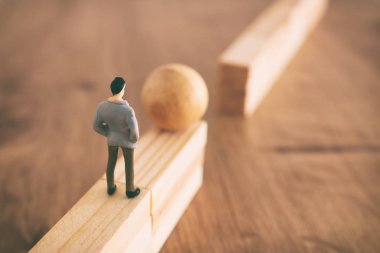 İş ve meydan okuma kavramı görüntü. Bir adam yüksek bir duvarın üzerinden bir top rulo ve bir boşluk üzerinden geçmek zorunda. Problem çözme ve karar verme.