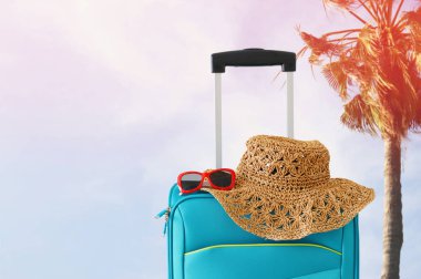 Tatil. seyahat konsepti. tropikal arka plan önünde mavi bavul
