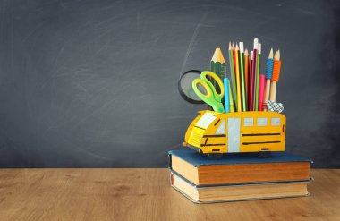 eğitim ve okul kavramına geri dön. kalemler sınıf kara tahta önünde ahşap masa üzerinde otobüs gibi standı