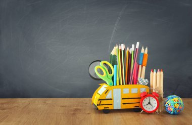 eğitim ve okul kavramına geri dön. kalemler sınıf kara tahta önünde ahşap masa üzerinde otobüs gibi standı