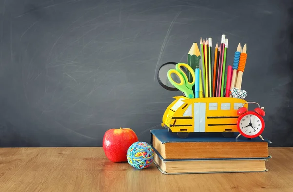 Eğitim ve okul kavramına geri dön. kalemler sınıf kara tahta önünde ahşap masa üzerinde otobüs gibi standı — Stok fotoğraf