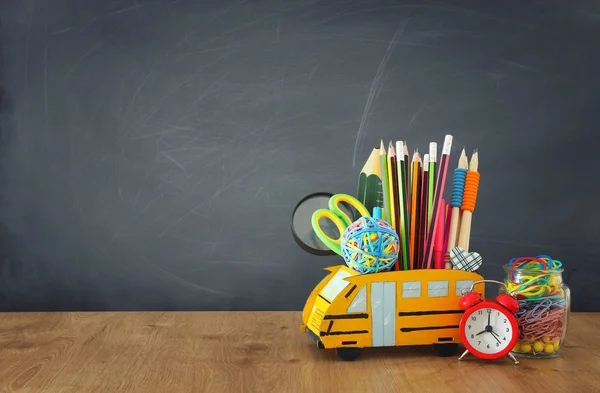 Εκπαίδευση και την επιστροφή στη σχολική έννοια. μολύβια σταθεί ως λεωφορείο πάνω από ξύλινο γραφείο μπροστά από τον πίνακα τάξη — Φωτογραφία Αρχείου