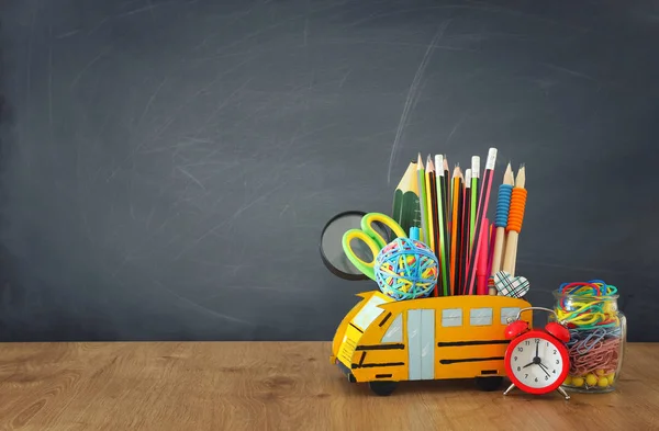 Education and back to school concept. pencils stand as bus over wooden desk infront of classroom blackboard — Stock Photo, Image