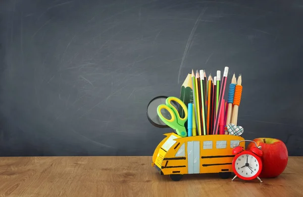 Образование и возврат к концепции школы. карандаши стоят как автобус над деревянным столом перед классной доской — стоковое фото