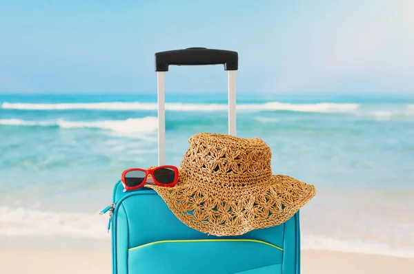 Vakantie. reis concept. blauwe koffer Infront van tropische achtergrond — Stockfoto