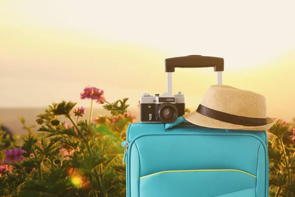 Recreatie beeld van reiziger bagage, camera en Fedora hoed Infront van een landelijke lanscape. vakantie-en vakantie concept — Stockfoto