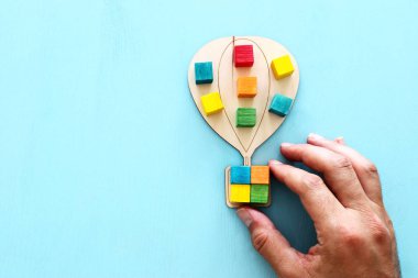 Mavi Masa, insan kaynakları ve yönetim konsepti üzerine renkli küpler ile ahşap hava balonu iş görüntüsü