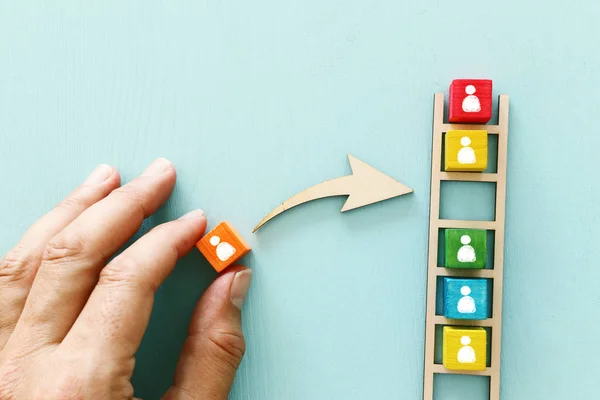 Zakelijk beeld van houten ladder met mensen pictogrammen over blauwe tafel, human resources en management concept — Stockfoto