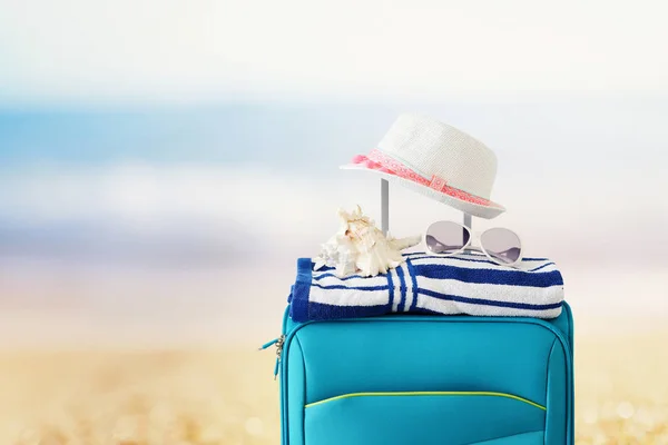 Vakantie. reis concept. blauwe koffer met vrouwelijke hoed, zee ze — Stockfoto