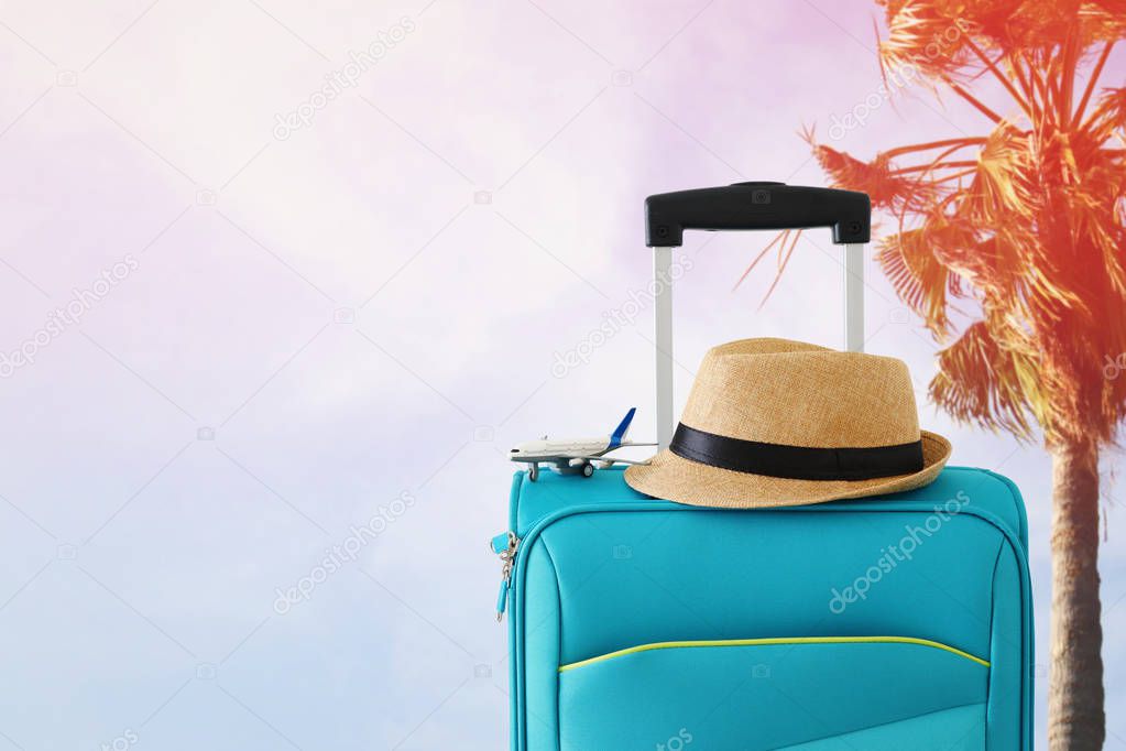 holidays. travel concept. blue suitcase and airplane toy infront
