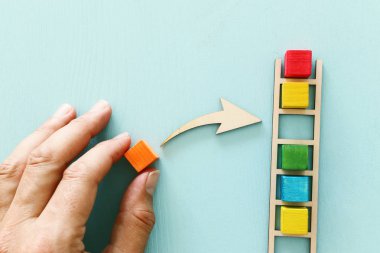 Mavi Masa, insan kaynakları ve yönetim konsepti üzerine renkli küpler ile ahşap merdiven iş görüntüsü