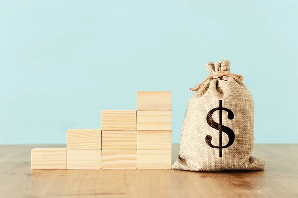 Bedrijfsimago van een zak met geld over houten bureau — Stockfoto