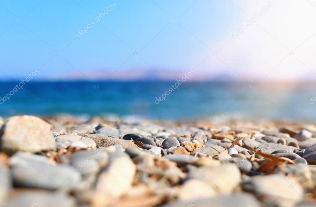 holidays image of beach in front of summer sea with pebble stones background. selective focus