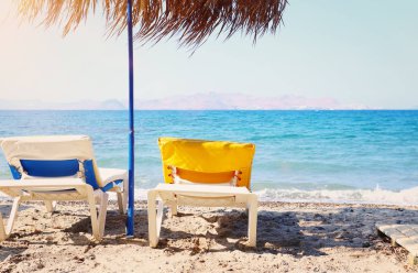 şemsiye altında tropikal deniz ve plaj sandalyeleri tatil resmi. Yaz seyahati ve tatil konsepti