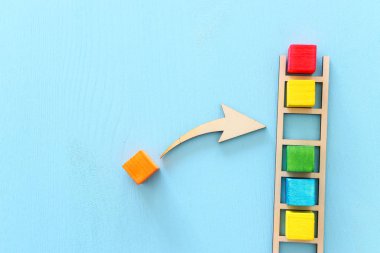 Mavi Masa, insan kaynakları ve yönetim konsepti üzerine renkli küpler ile ahşap merdiven iş görüntüsü