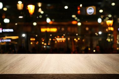 Soyut bulanık restoran ışıklarının önündeki ahşap masanın arkaplan resmi