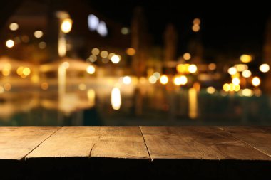 Soyut bulanık restoran ışıklarının önündeki ahşap masanın arkaplan resmi
