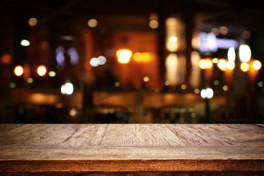 Soyut bulanık restoran ışıklarının önündeki ahşap masanın arkaplan resmi