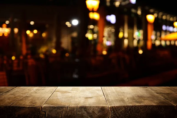 Fundo Imagem da mesa de madeira na frente de abstrato desfocado restaurante luzes — Fotografia de Stock