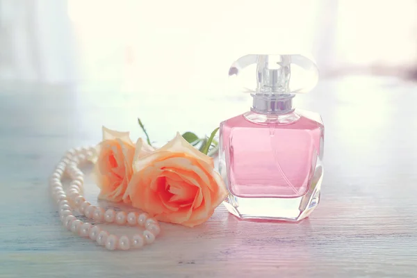 Belleza / moda Imagen de una elegante botella de perfume, perlas blancas y delicadas rosas sobre fondo pastel. vintage imagen filtrada —  Fotos de Stock