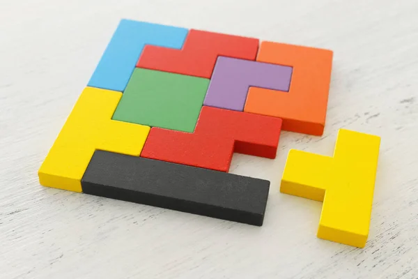 Ahşap masa üzerinde renkli bir kare tangram bulmaca iş konsepti görüntü — Stok fotoğraf