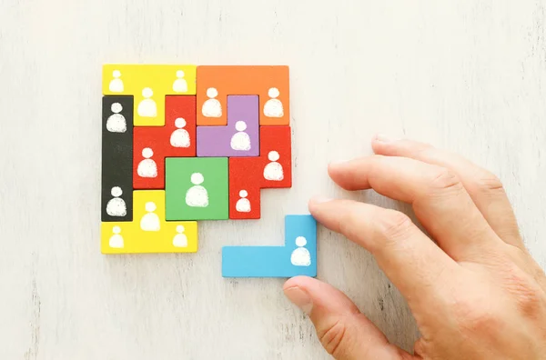 Affärsidé bild av tangram pusselblock med människor ikoner över trä bord, mänskliga resurser och förvaltning koncept — Stockfoto