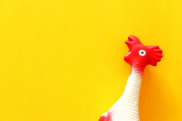 黄色のテーブルにゴム鶏のおもちゃの面白い背景 — ストック写真