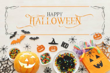 Cadılar Bayramı tatil görüntü. Kabaklar, yarasalar, beyaz ahşap arka plan üzerinde davranır. üst görünüm, düz yatıyordu