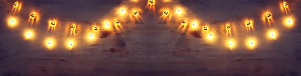 金の花輪ライトとハロウィーンの背景の休日の概念 — ストック写真