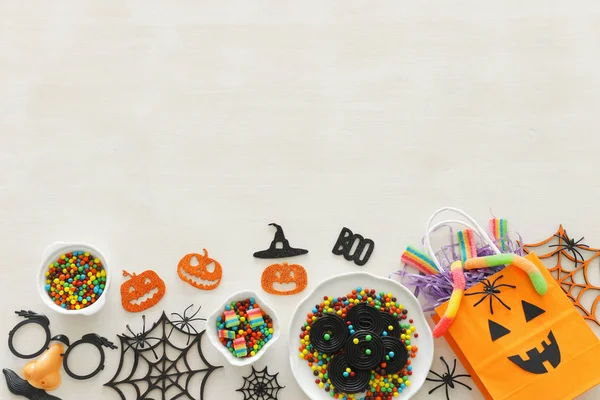 Vacaciones imagen de Halloween. Calabazas, murciélagos, golosinas sobre fondo de madera blanca. vista superior, plano — Foto de Stock
