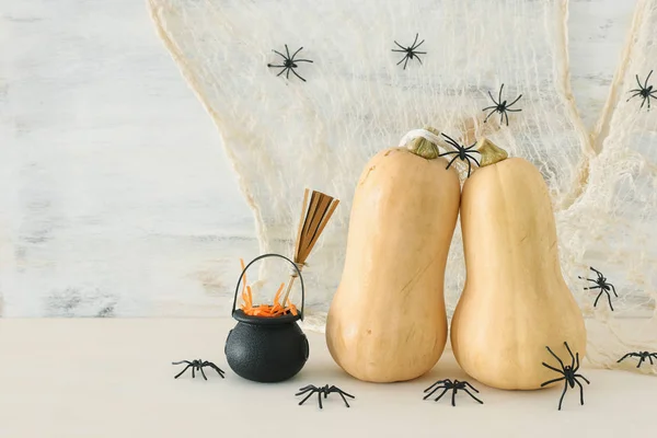 Vakantie foto van Halloween. Pompoenen, Witcher ketel, bezem, behandelt over witte houten tafel — Stockfoto