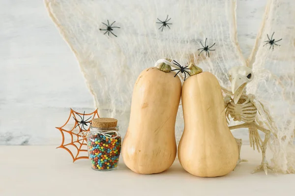 Vakantie foto van Halloween. Pompoenen, vleermuizen, traktaties over witte houten tafel — Stockfoto