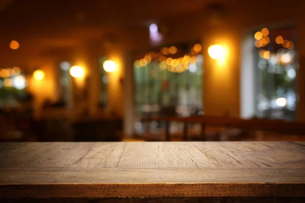 Soyut bulanık restoran ışıkları önünde ahşap masa arka plan — Stok fotoğraf