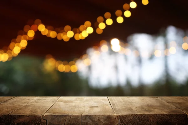 Fondo de la mesa de madera frente a las luces abstractas borrosas del restaurante — Foto de Stock