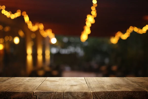 Fondo de la mesa de madera frente a las luces abstractas borrosas del restaurante —  Fotos de Stock