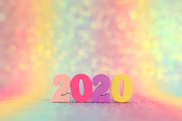 Holiday image of New Year 2020 concept. Wooden number and sparkling background