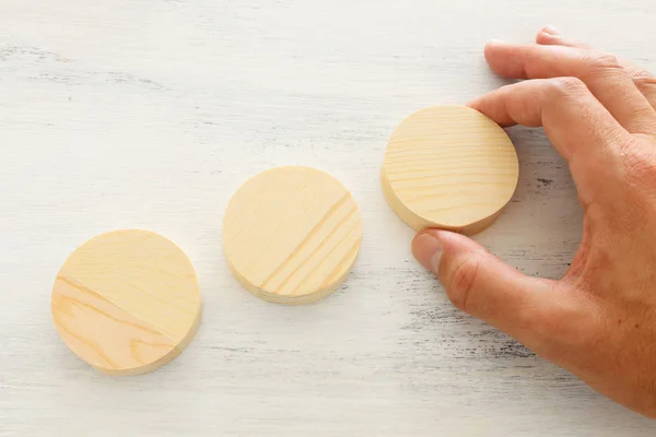 Business concept of man hand arranging wooden round blocks. mock up or template — Stock Photo, Image