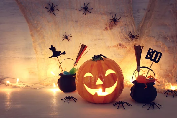 holidays halloween concept image. Pumpkin, spiders over wooden table
