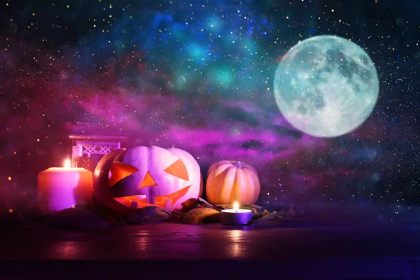 Immagine vacanze di Halloween. Zucche sul tavolo di legno di notte foresta spaventosa, infestata e nebbiosa — Foto Stock