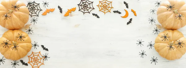 Vakantie Halloween afbeelding. pompoen, vleermuizen en spinnen over houten witte tafel. Top uitzicht, vlakke lag. Banner — Stockfoto