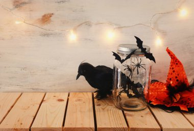 Cadılar Bayramı tatil görüntü. yarasalar, siyah karga ve ahşap masa üzerinde cadı şapka