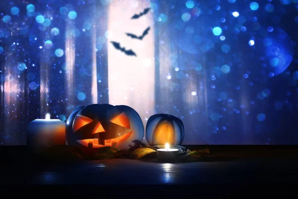 Vakantie concept van Halloween. Pompoenen over houten tafel 's nachts eng, spookachtig en mistige bos — Stockfoto