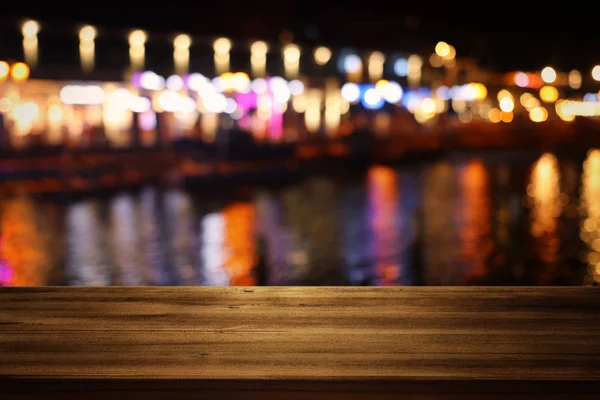 Fondo de la mesa de madera frente a las luces abstractas borrosas del restaurante — Foto de Stock