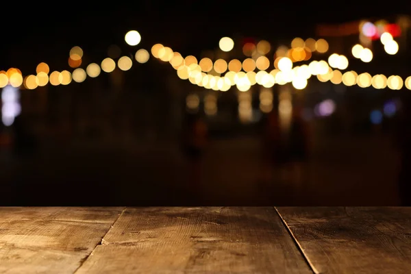 Background of wooden table in front of abstract blurred restaurant lights — Stock Photo, Image