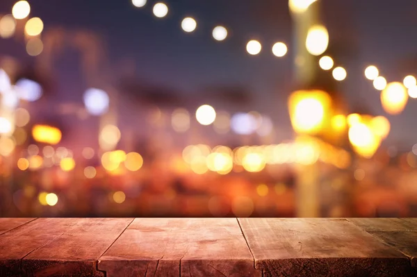 Fondo de la mesa de madera frente a las luces abstractas borrosas del restaurante —  Fotos de Stock