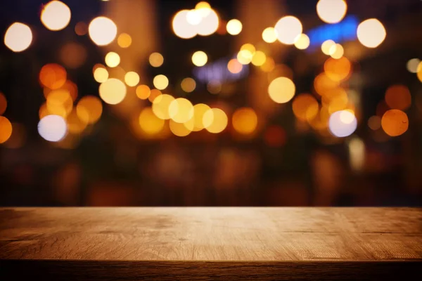 Tło drewnianego stołu przed abstrakcyjnym niewyraźne światła restauracji — Zdjęcie stockowe