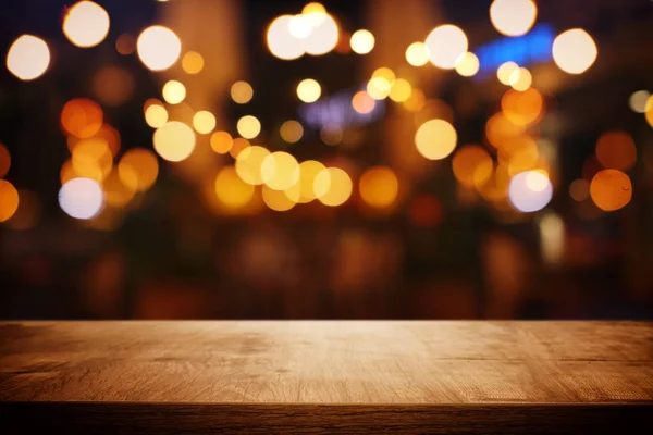 Fondo de la mesa de madera frente a las luces abstractas borrosas del restaurante —  Fotos de Stock