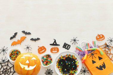 Cadılar Bayramı tatil görüntü. Kabaklar, yarasalar, beyaz ahşap arka plan üzerinde davranır. üst görünüm, düz yatıyordu